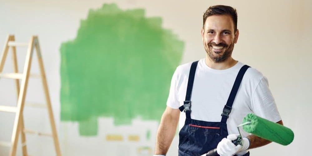 Man paiting the walls inside a house.